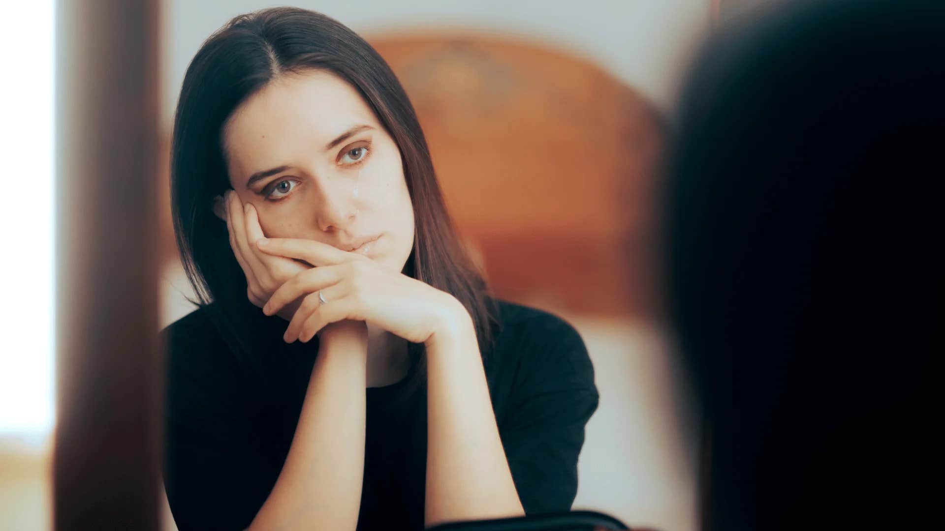 woman looking in the mirror talking down to herself