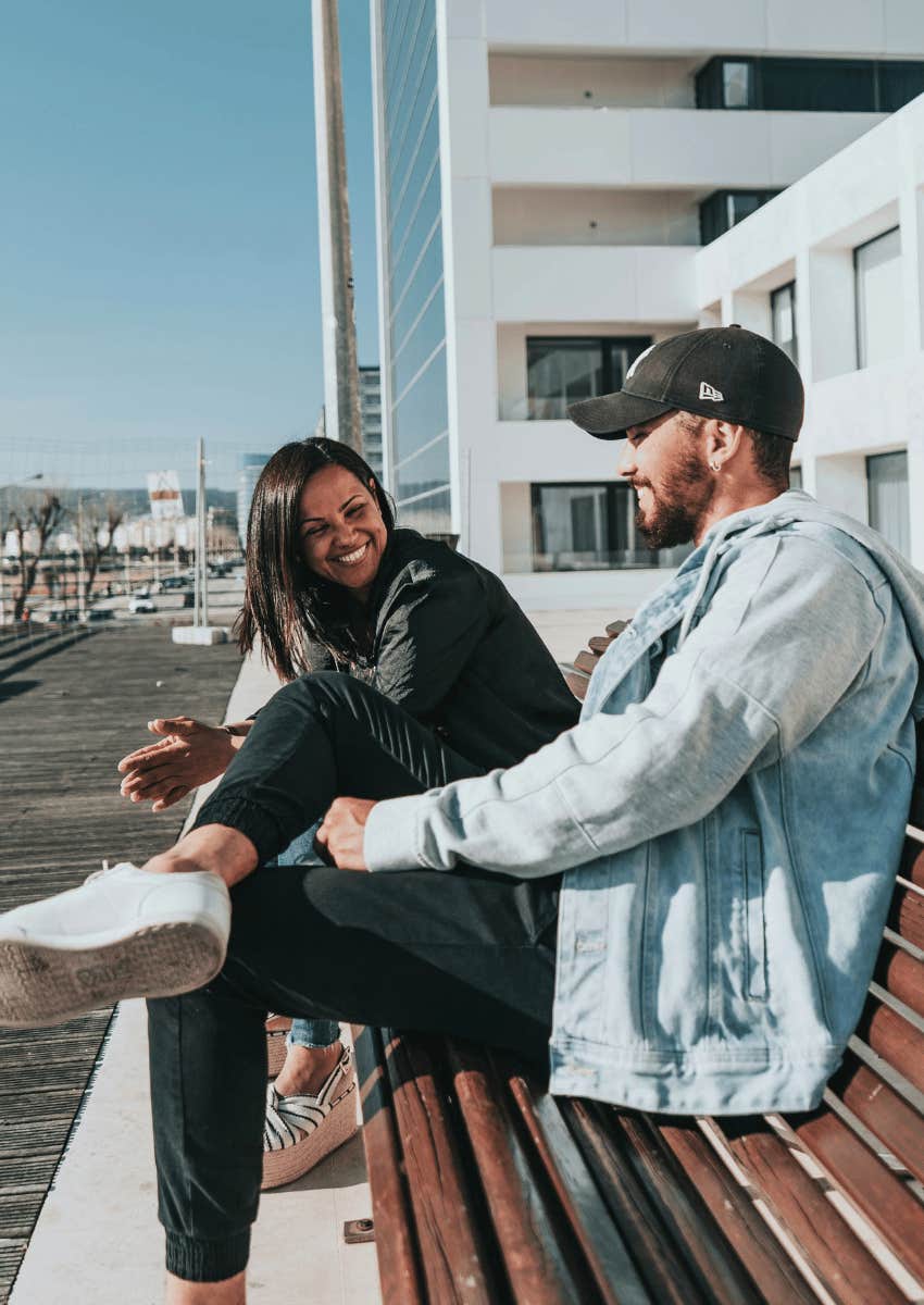 happy couple talking on an outdoor bench