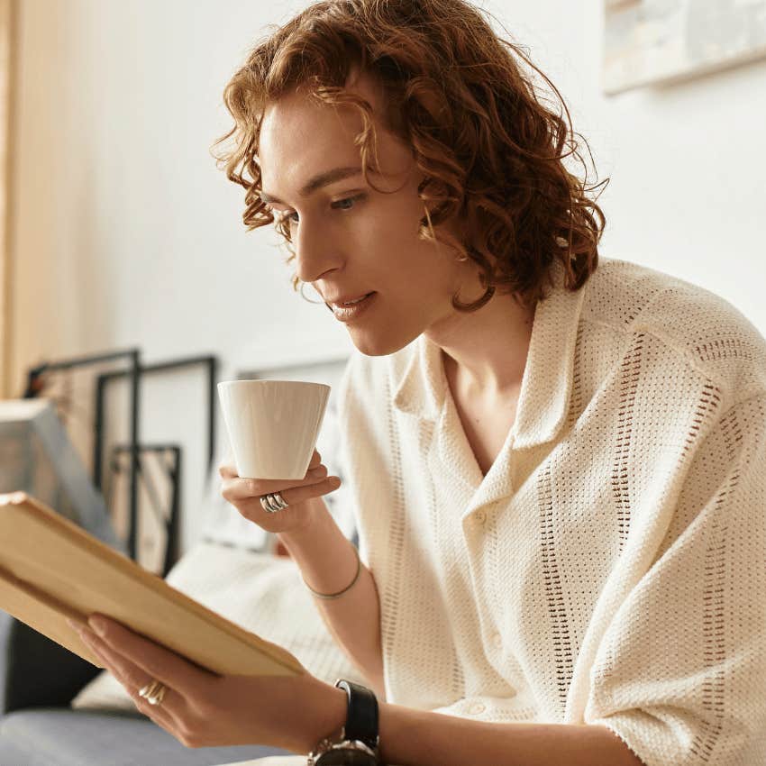 happy intelligent man reading a book keeping time for himself