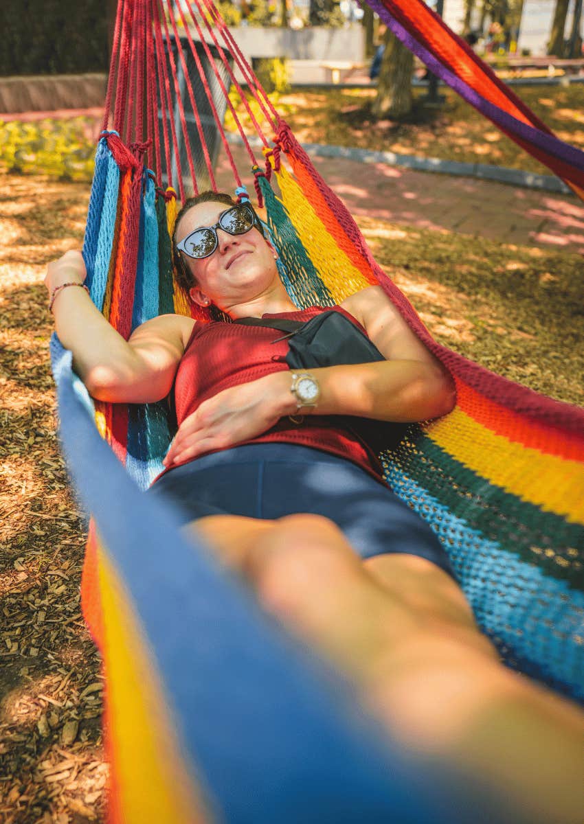 happy woman laying in a hammock doing nothing