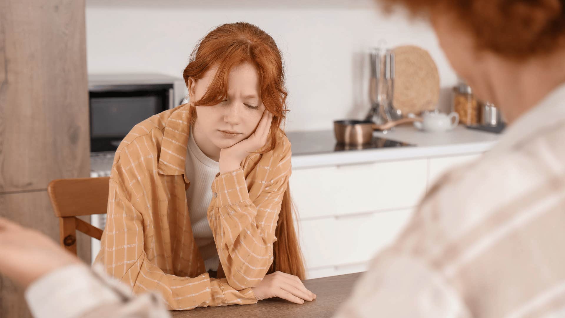 mother scolding her teen daughter for asking questions