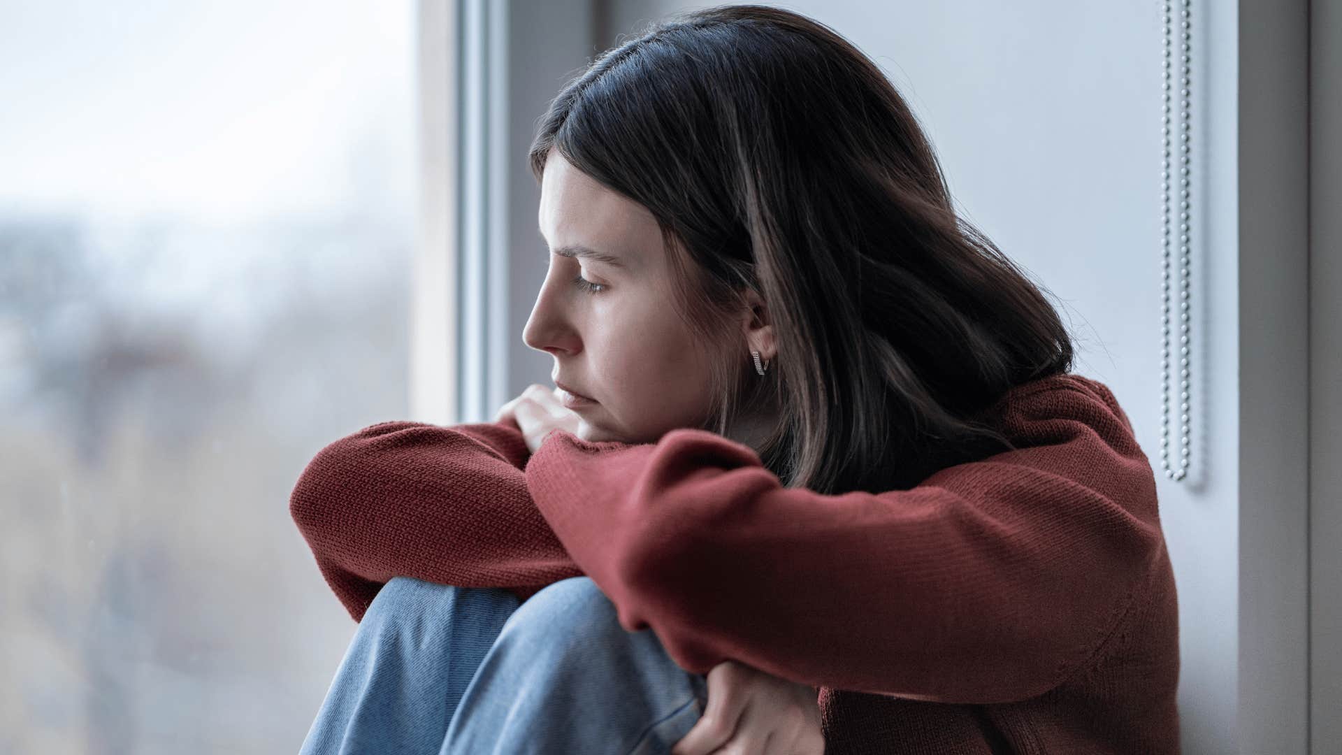 sad teen girl staring out the window