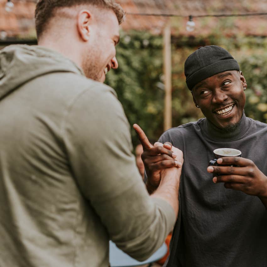two men laughing shaking hands as best friends