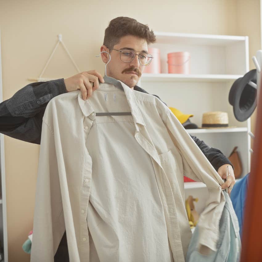 man holding up shirt taking pride in the clothing he wears