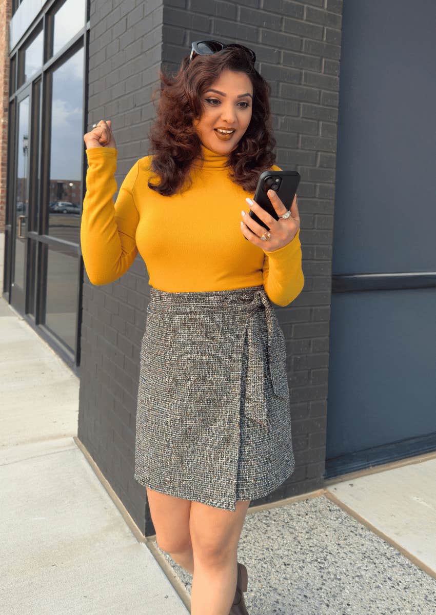 hopeful woman looking down at her phone