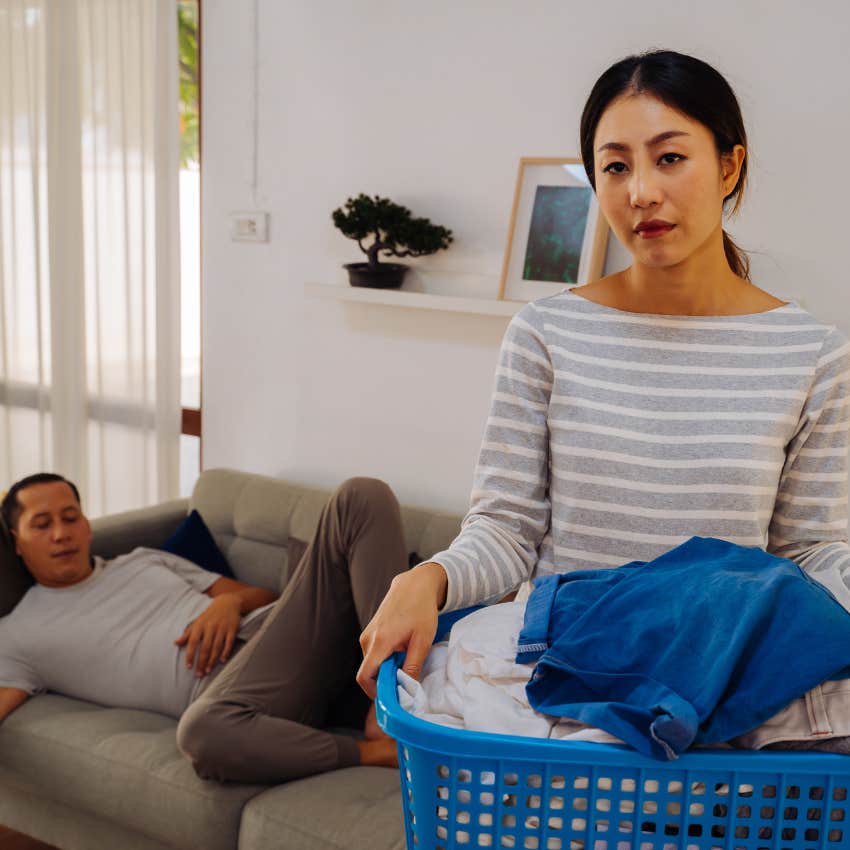wife doing laundry annoyed with lazy husband who hasn't just helped