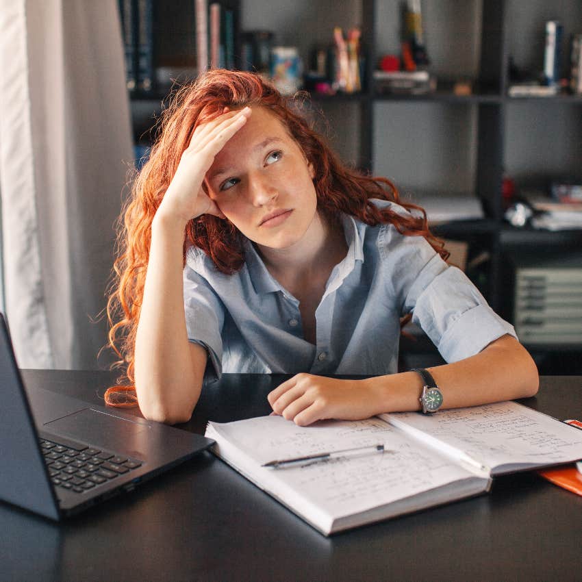 female student bored while completing assignment