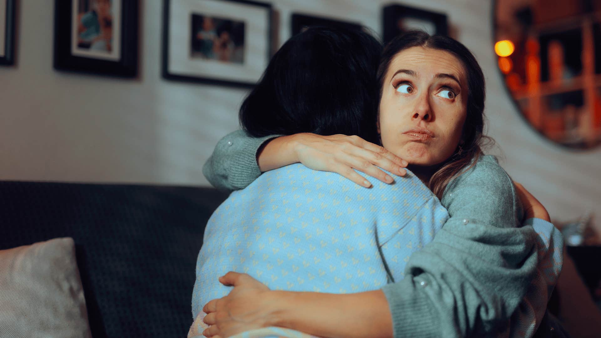 woman reluctantly hugging friend and not smiling