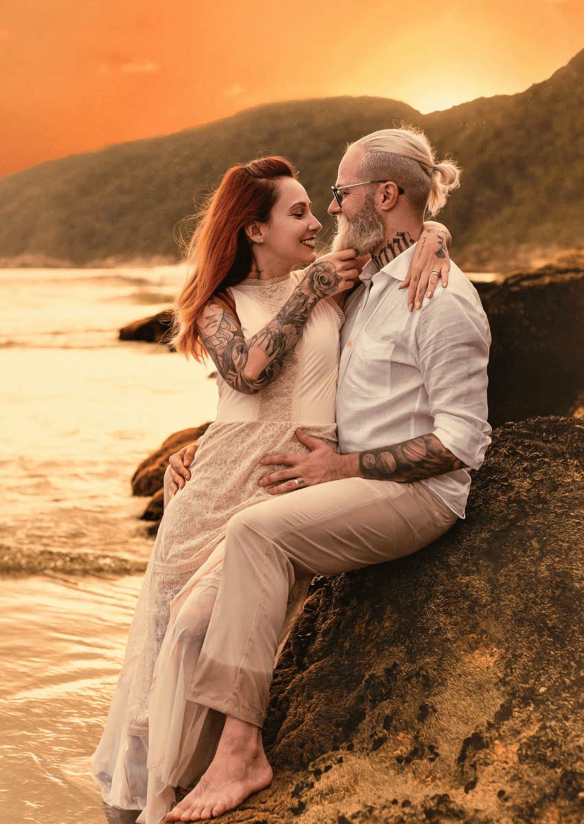 loving age gap couple posing on a beach