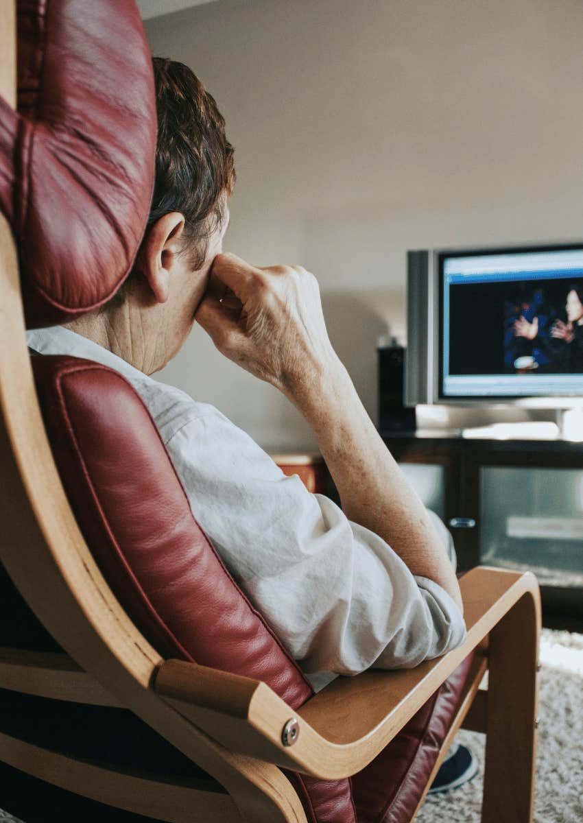 man sitting in a chair watching tv