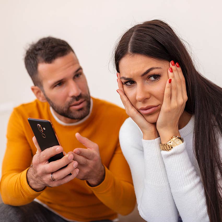 man interrogating his partner about her phone, woman annoyed