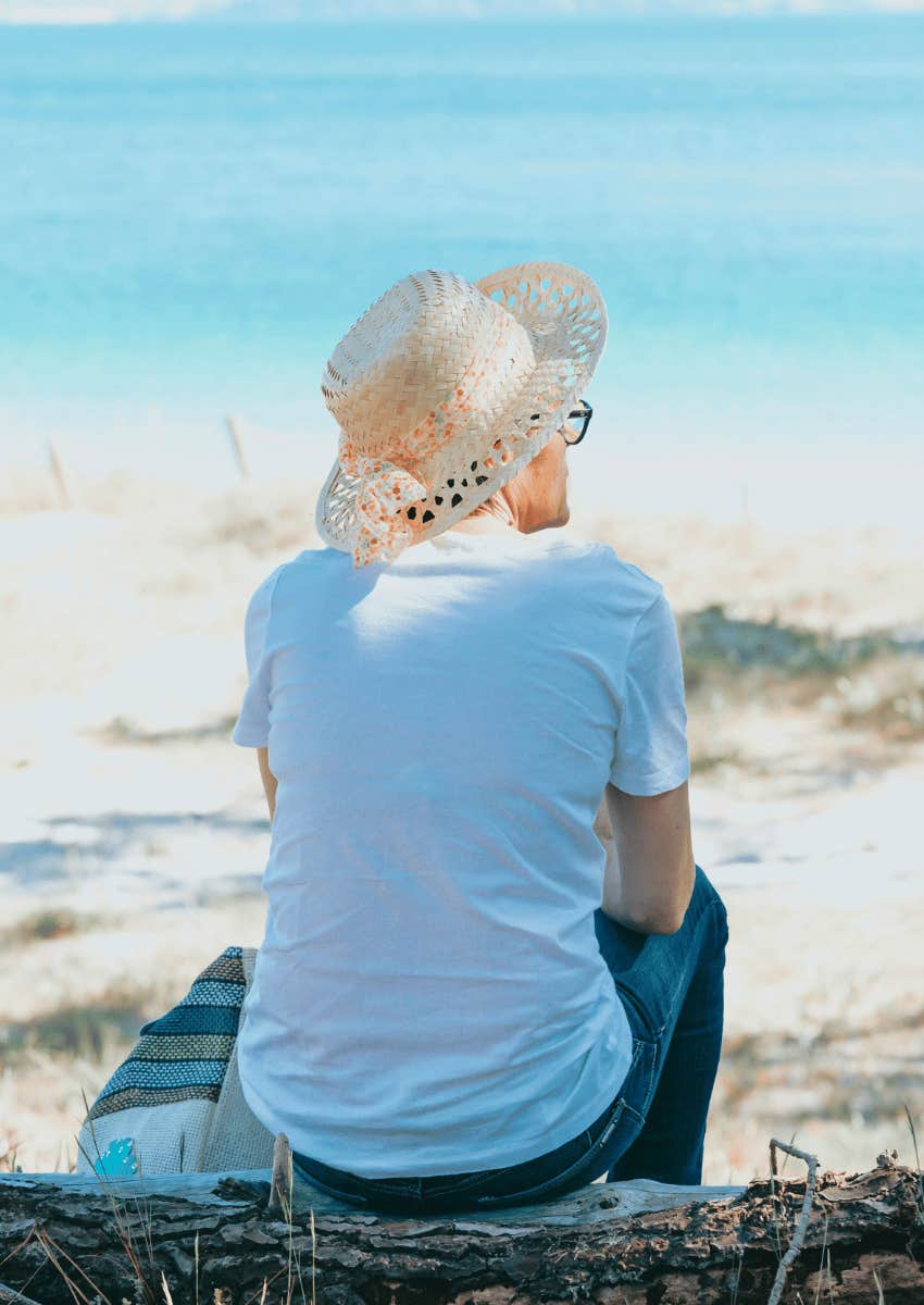 middle-aged person sitting alone on the beach