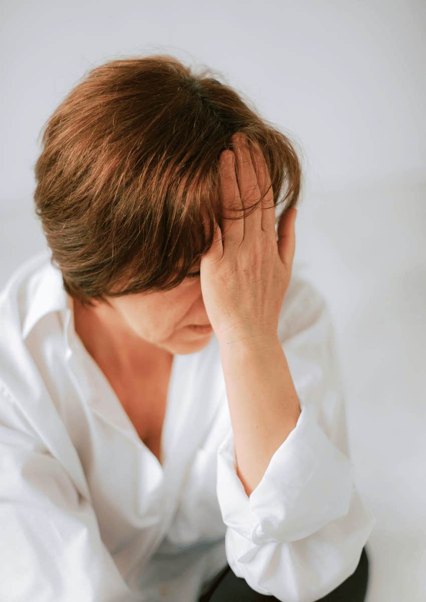 worried middle aged person covering face