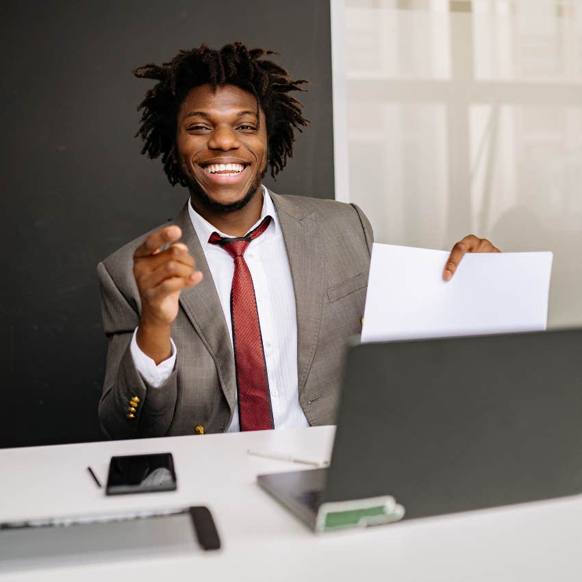 young man at work looking happy and motivated