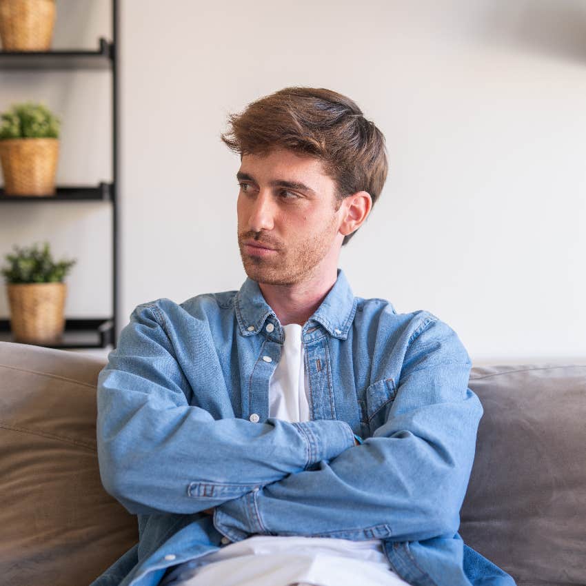 man sitting on couch thinking of tasks addicted to stress