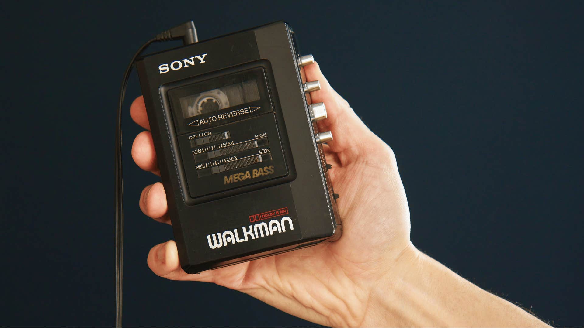 man holding a walkman as he is listening to music