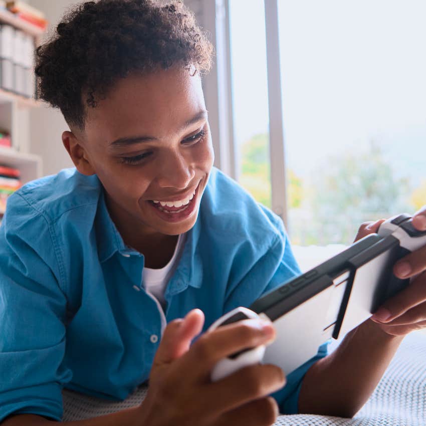Gen Z teen playing handheld games at home