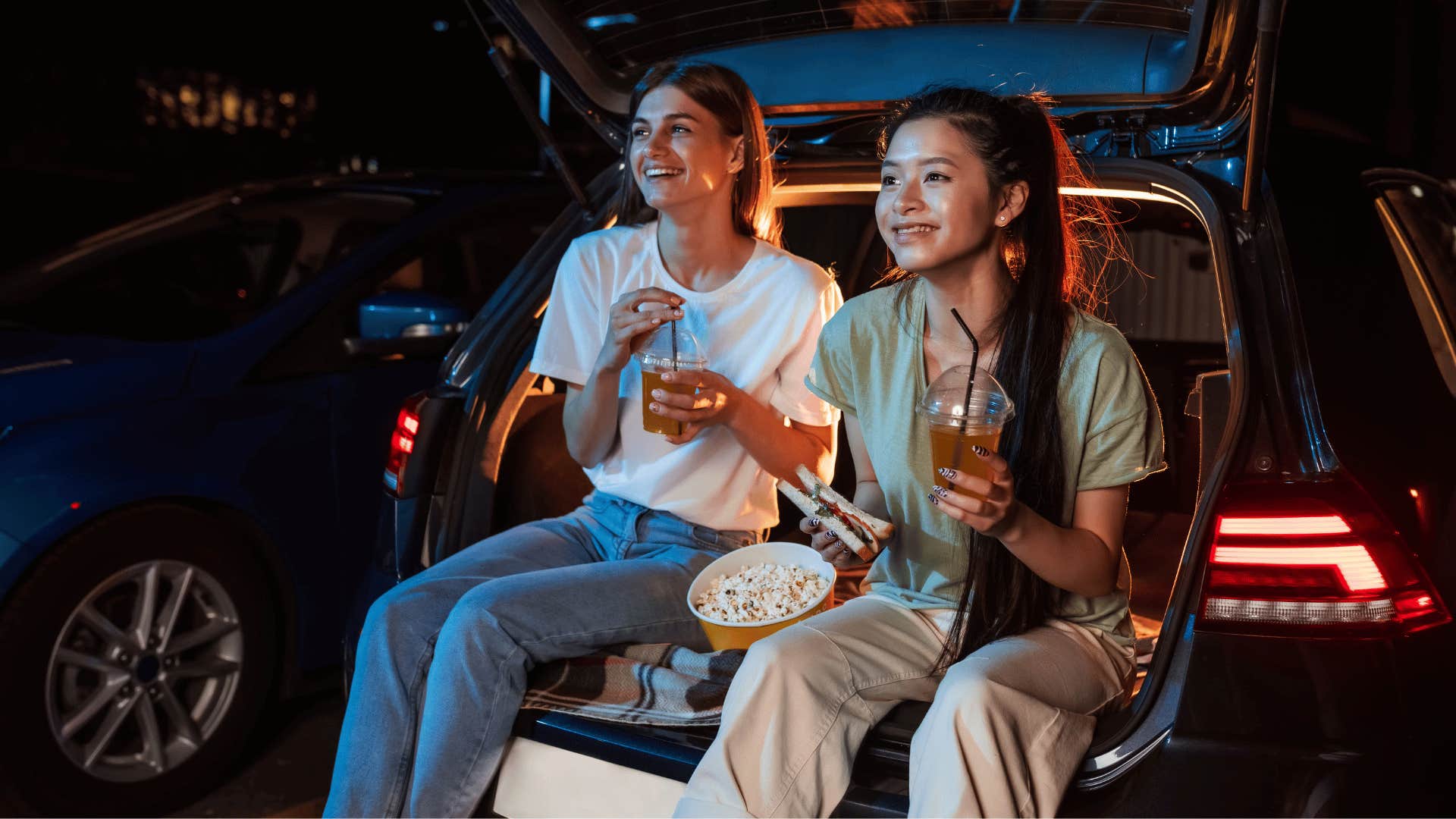 teenagers at a drive-in movie eating popcorn