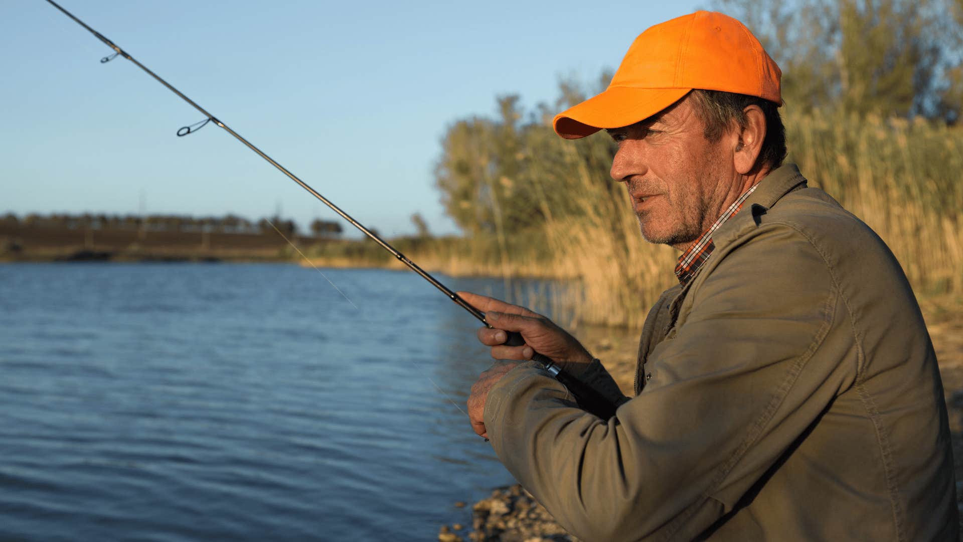 middle aged man fishing in a lake