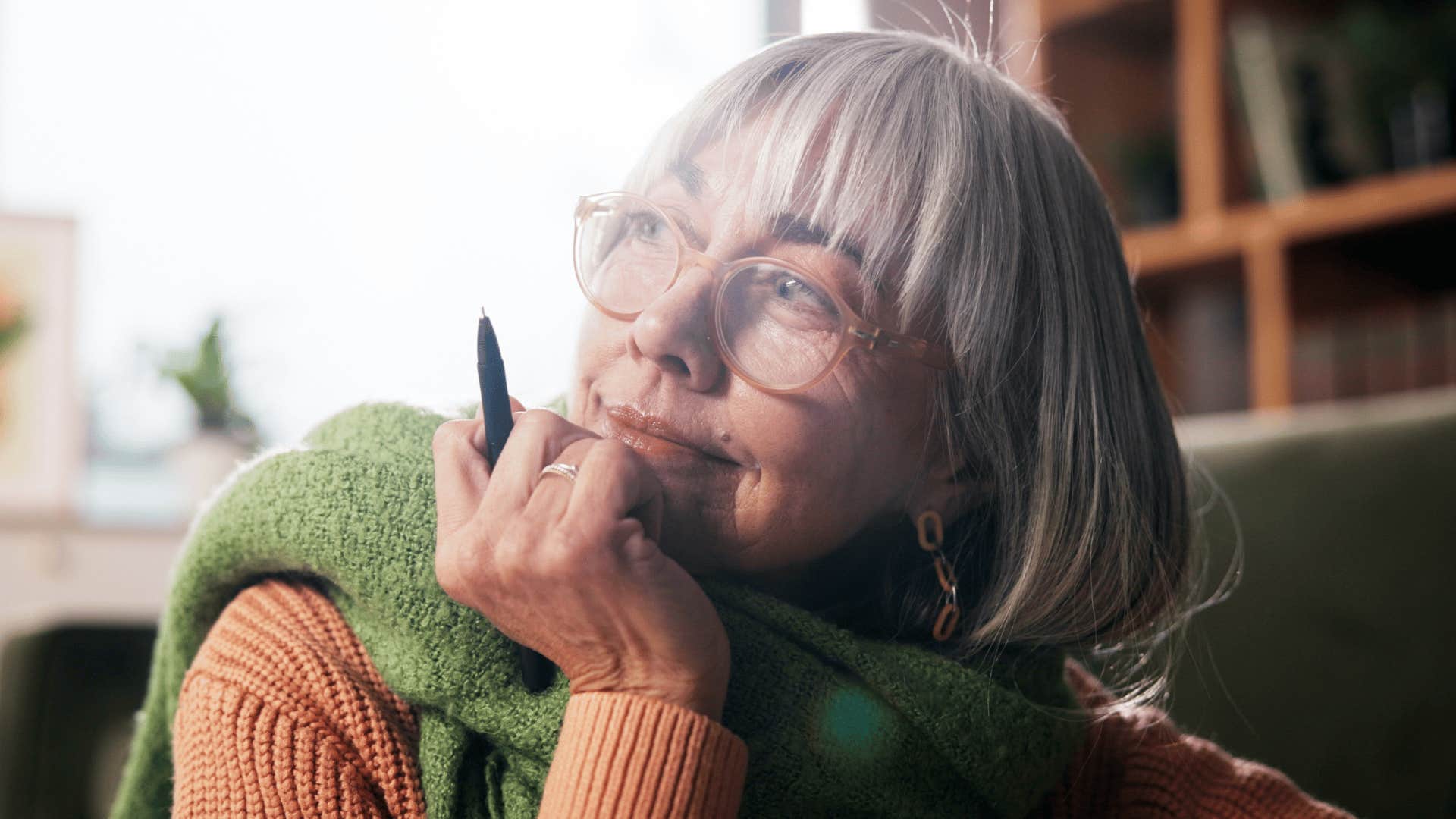 older pensive woman journaling at home