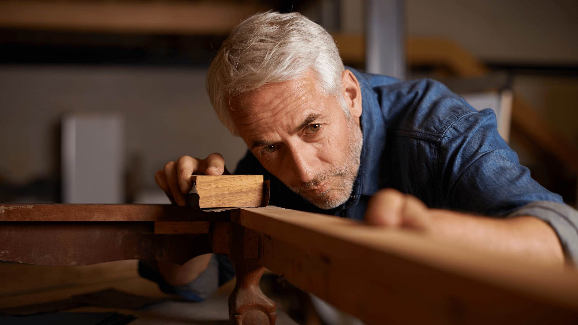older man woodworking in his garage at home