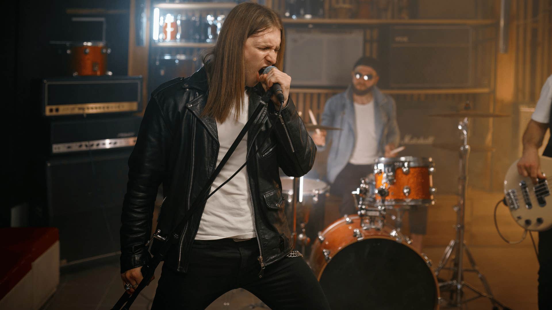 man singing in garage band wearing a leather jacket
