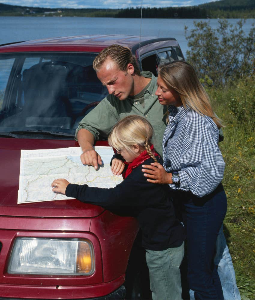 family using a paper map like in the 70s and 80s