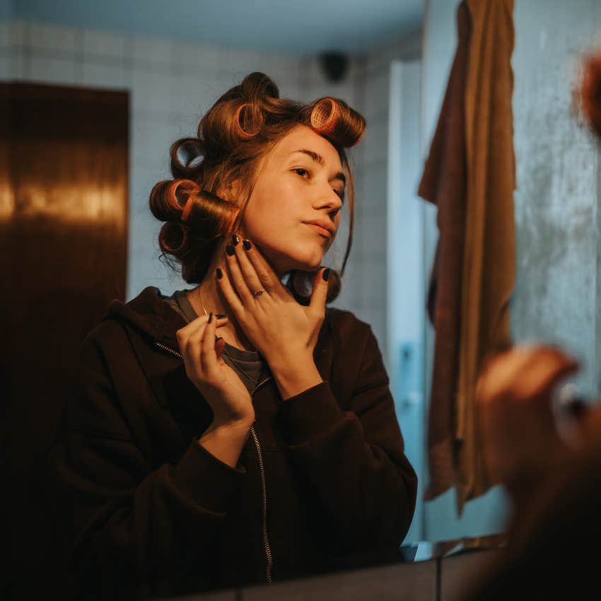 young woman using curlers for voluminous hair