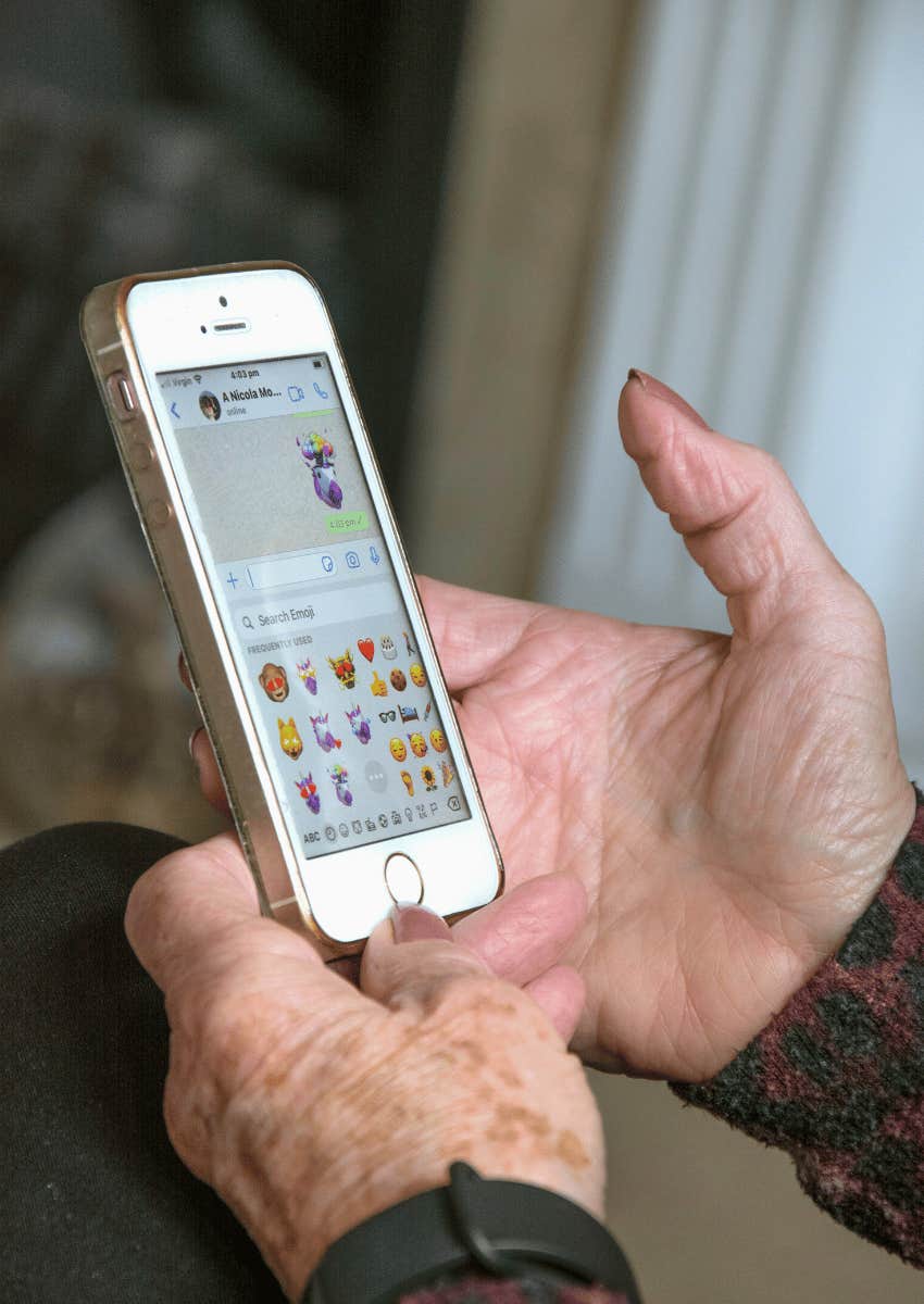 old woman's hands using emojis while texting