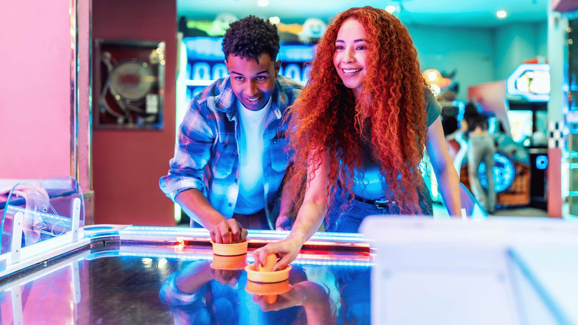 millennial friends playing arcade games having fun