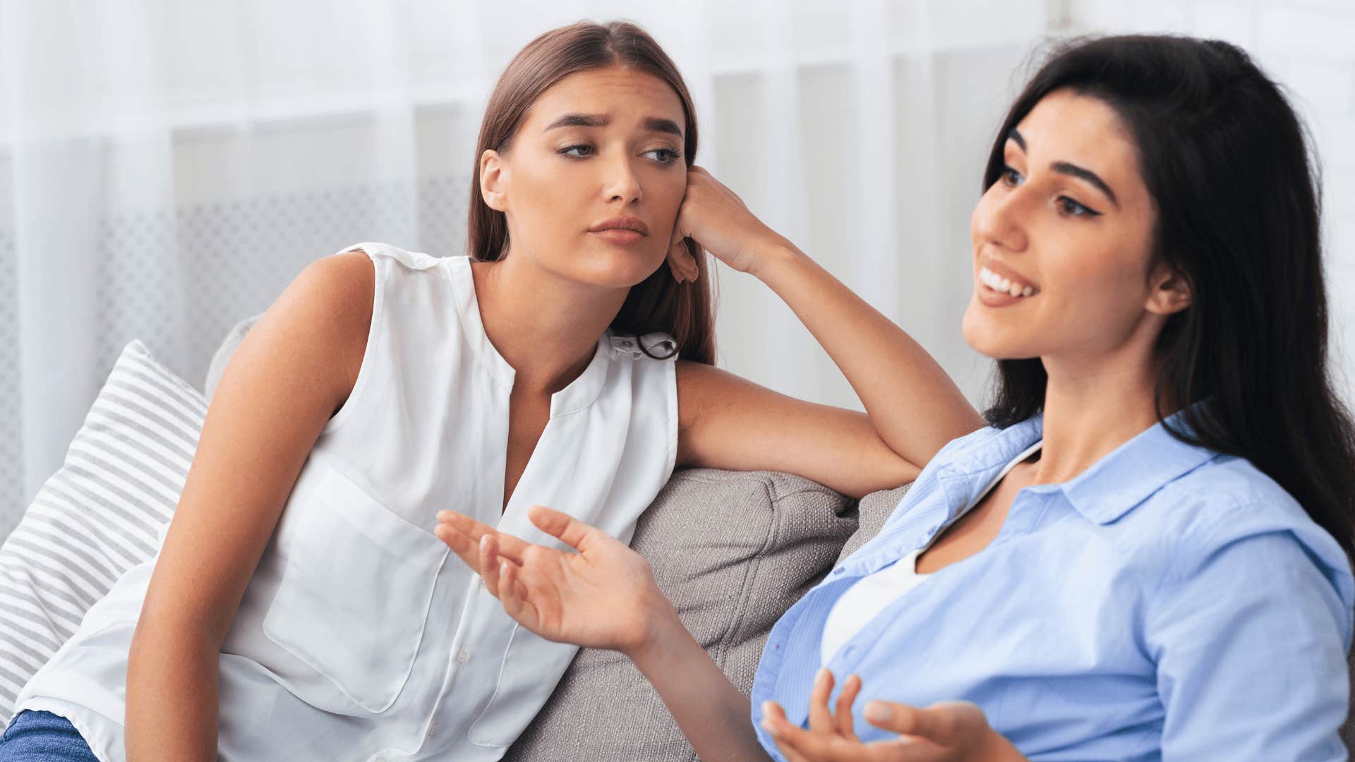 woman staring at friend unamused reacting to her success