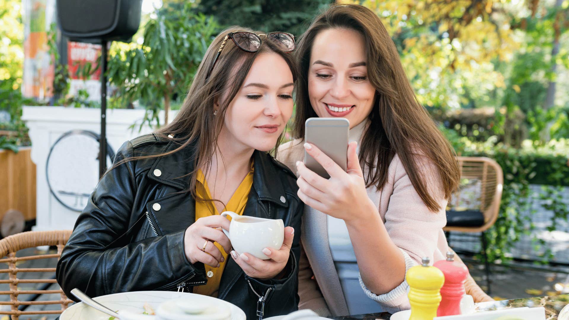 two friends gossiping excessively looking at phone