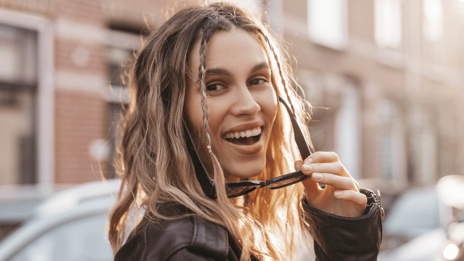 eccentric woman putting her sunglasses on smiling