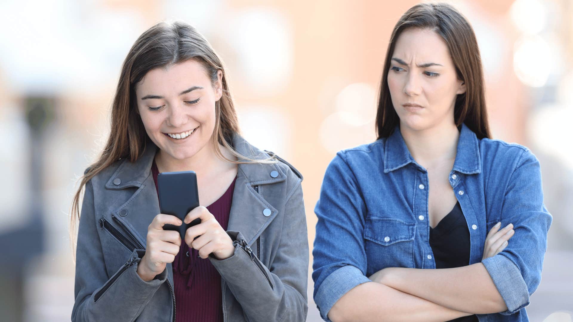 woman watching friend text feeling competitive