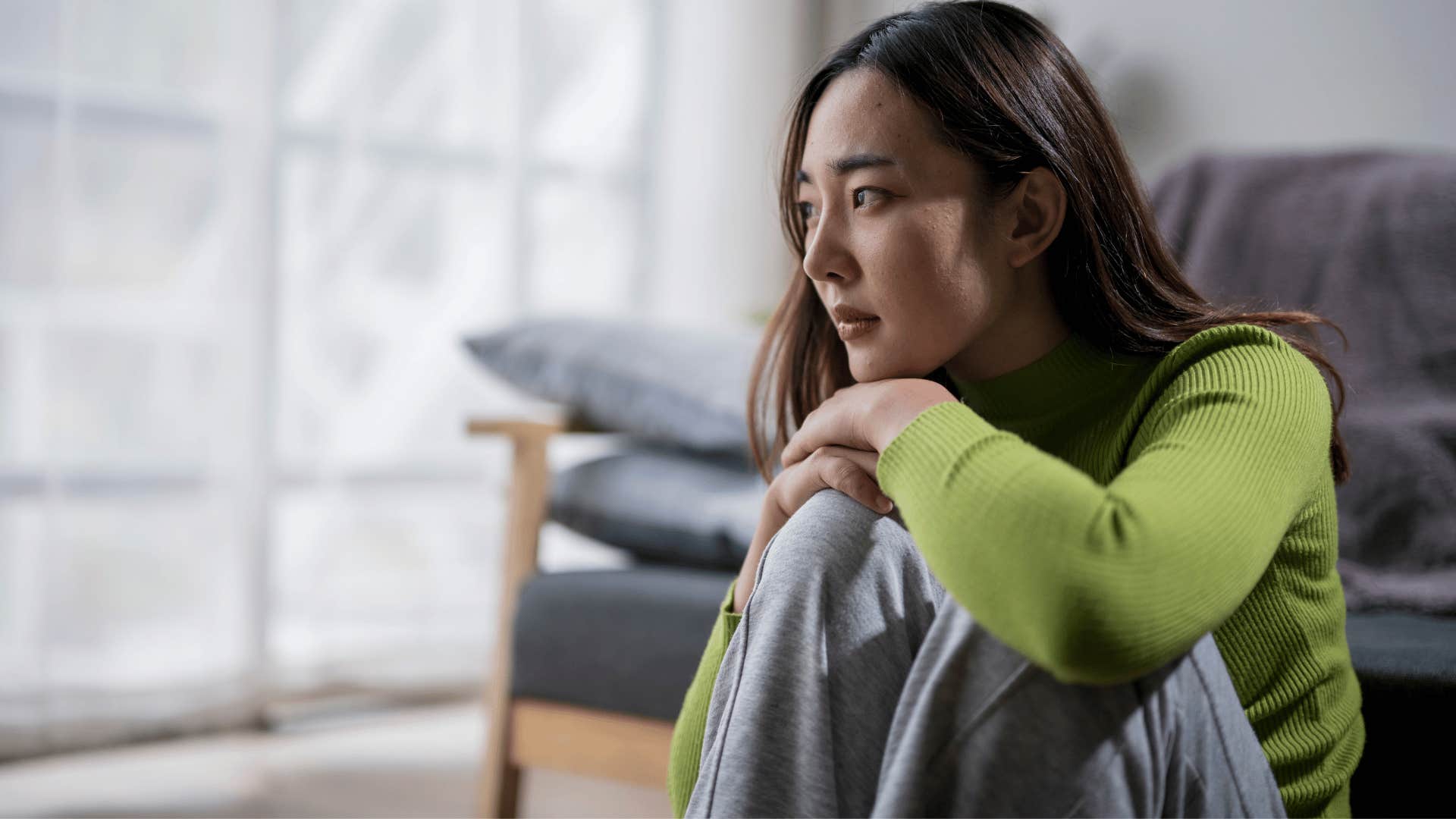 woman in green shirt looking upset as she thinks i'm used to it don't worry