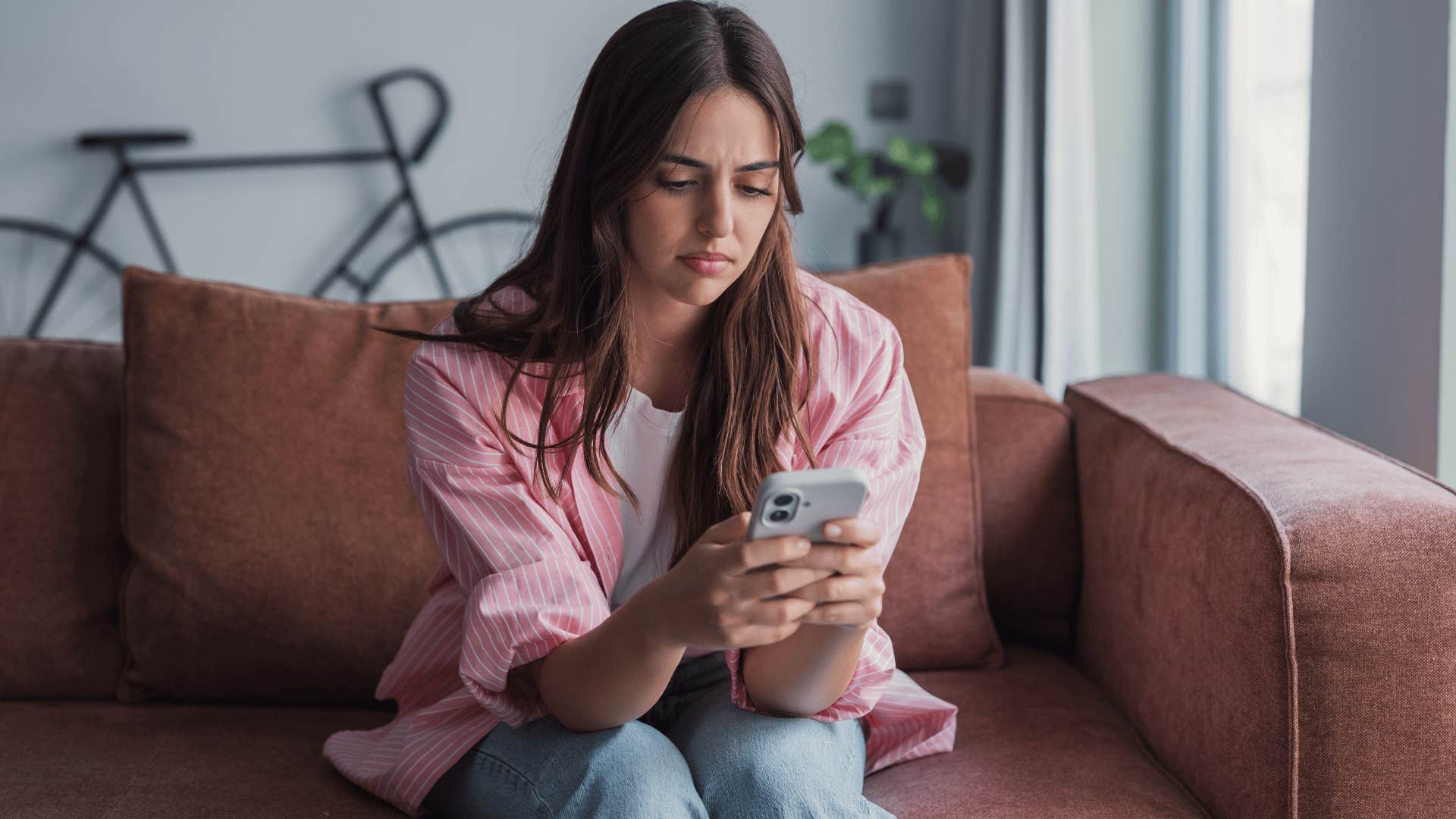 woman in pink jacket on the phone texting as she says i knew it'd end up like this