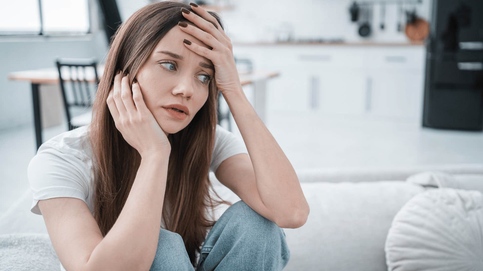 woman in white shirt thinking what's the point as she looks stressed out