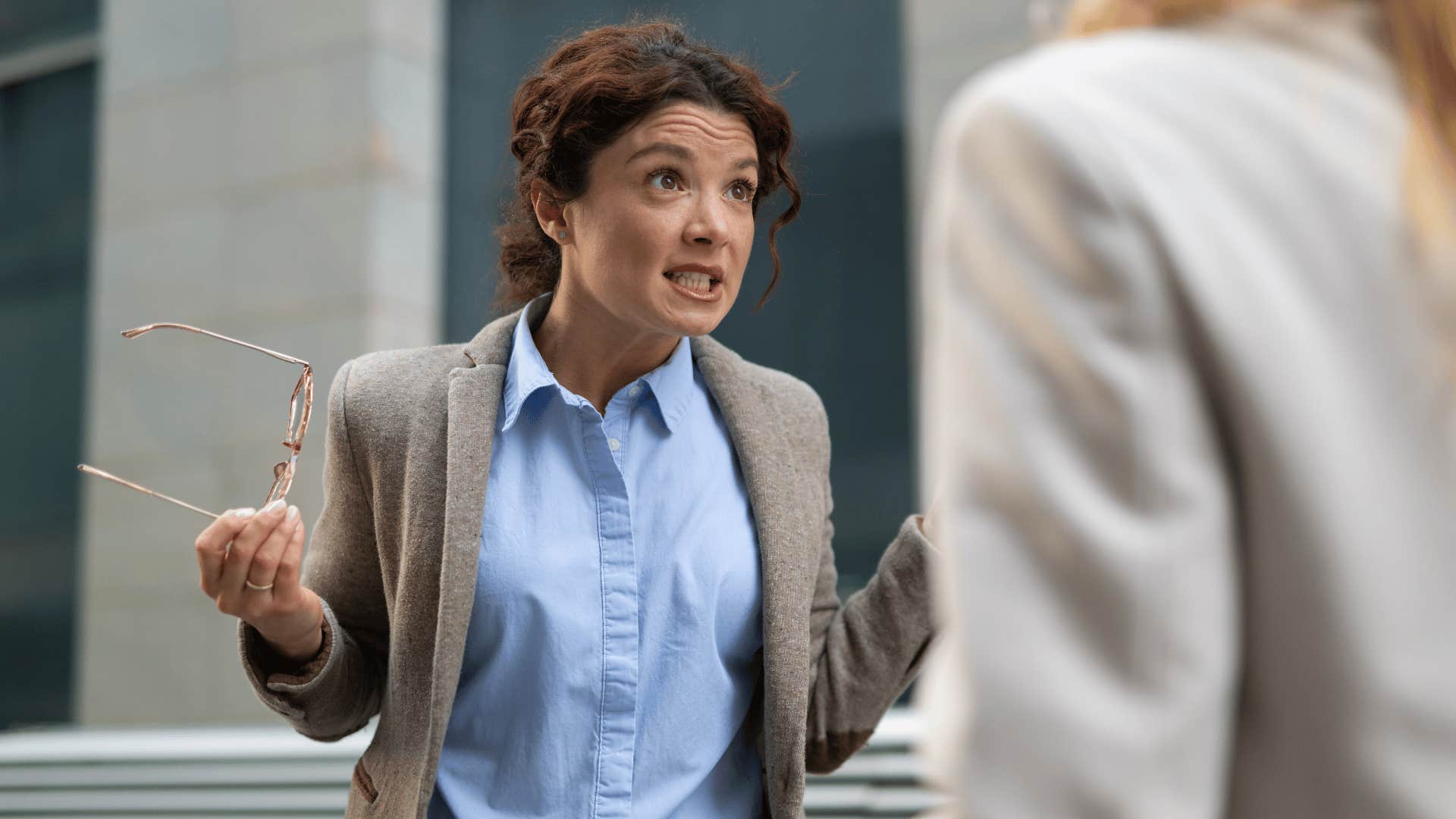 woman arguing with colleague at work telling them that's not my problem