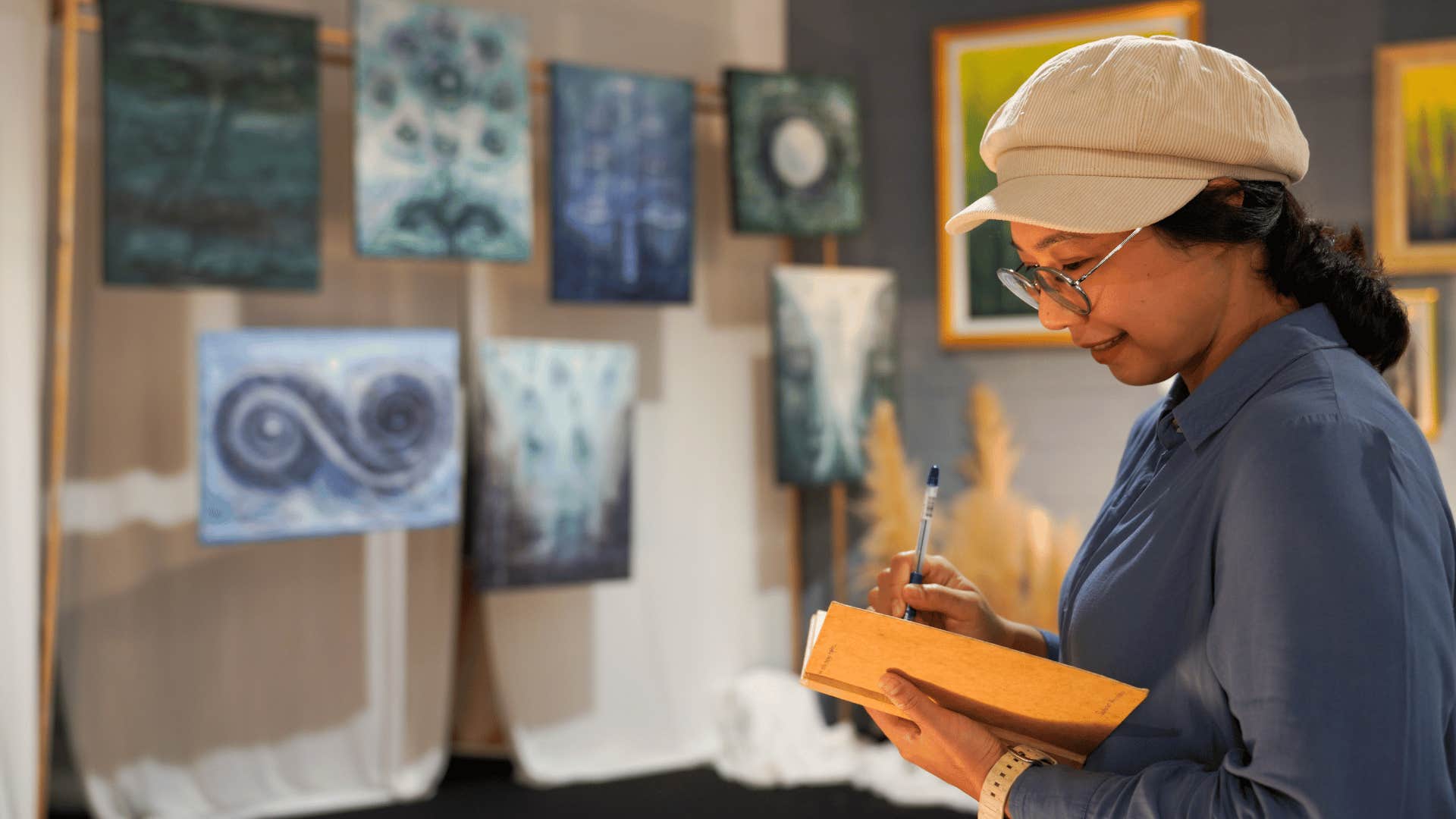 creative woman in an art studio writing in a journal