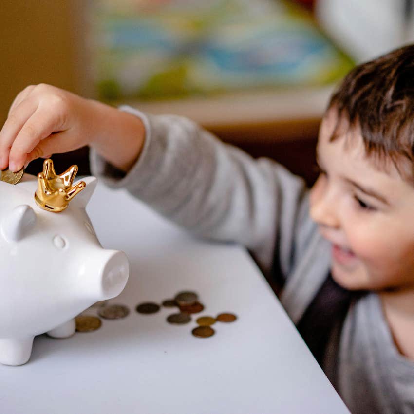 little boy saving a penny in his piggy bank