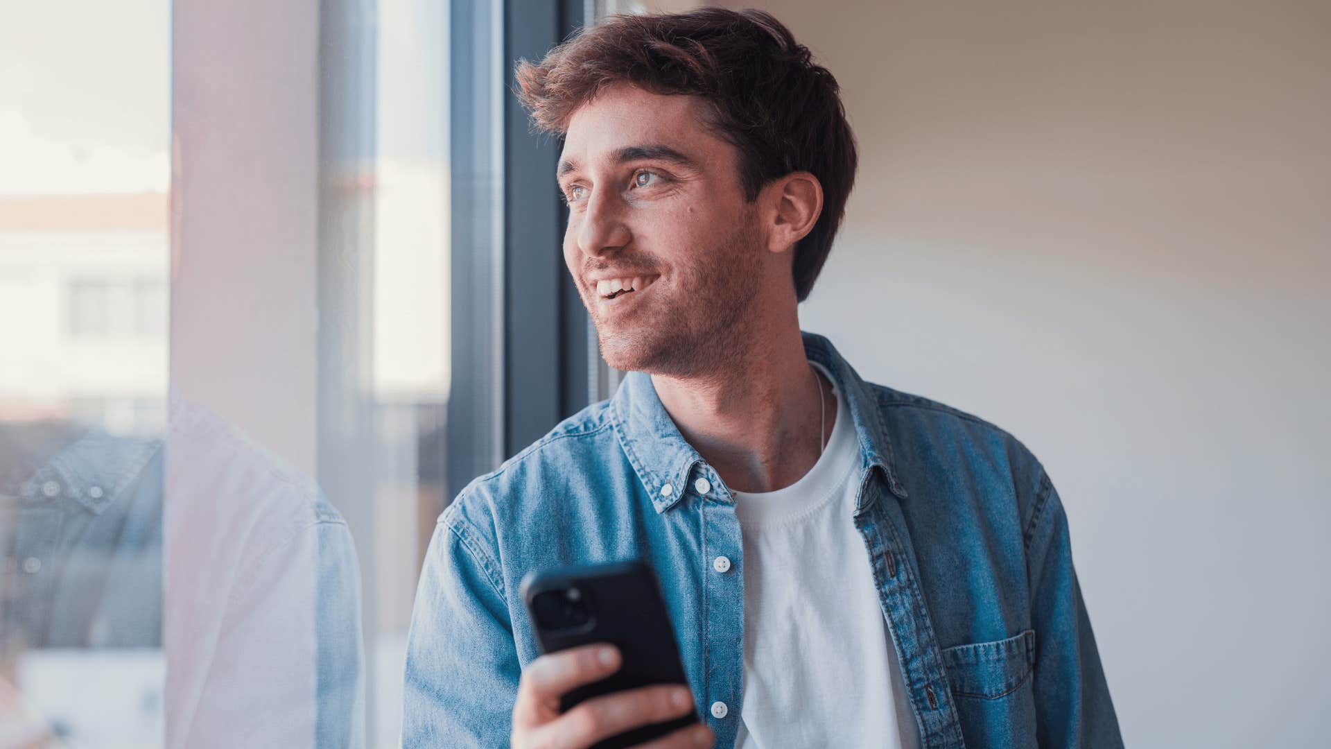 man with strong internal validation on his phone while he daydreams