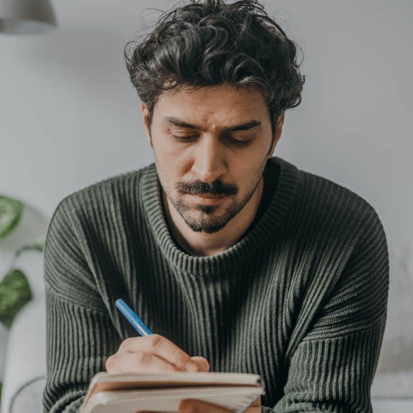 unique authentic man researching and taking notes in journal