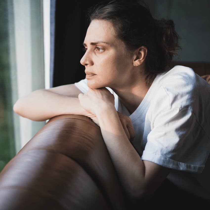 highly sensitive woman sitting alone looking at the rain outside
