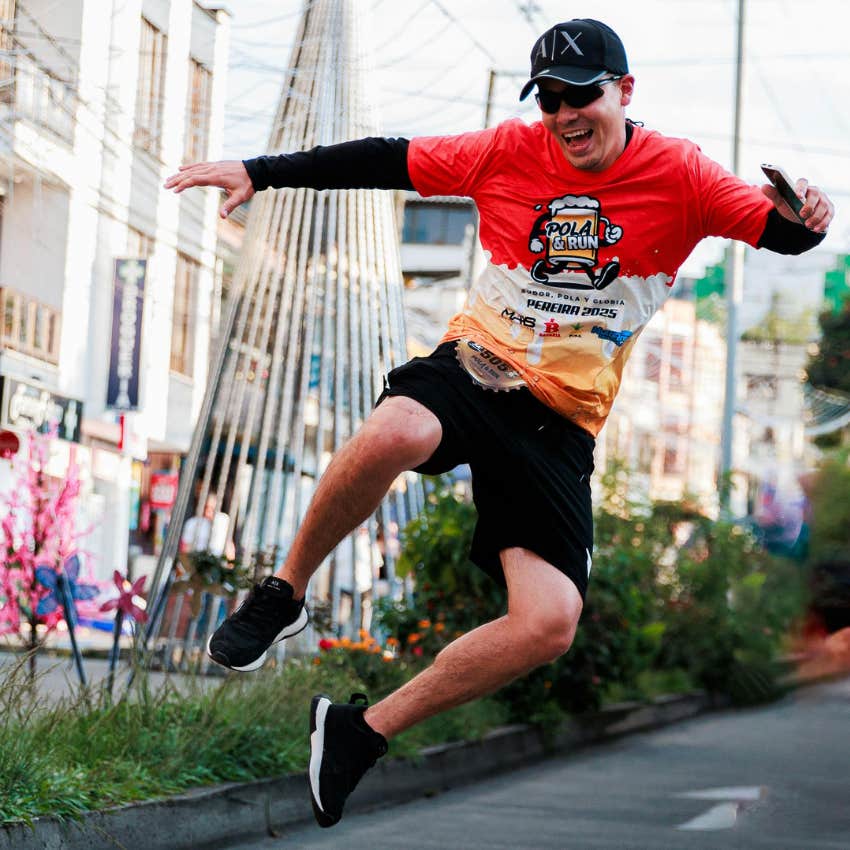 highly energetic man jumping in the street without his phone