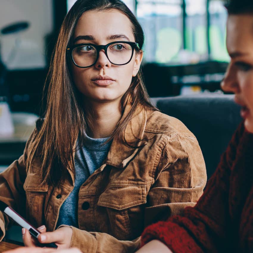 woman bored in conversation with friend telling her let's go one step further