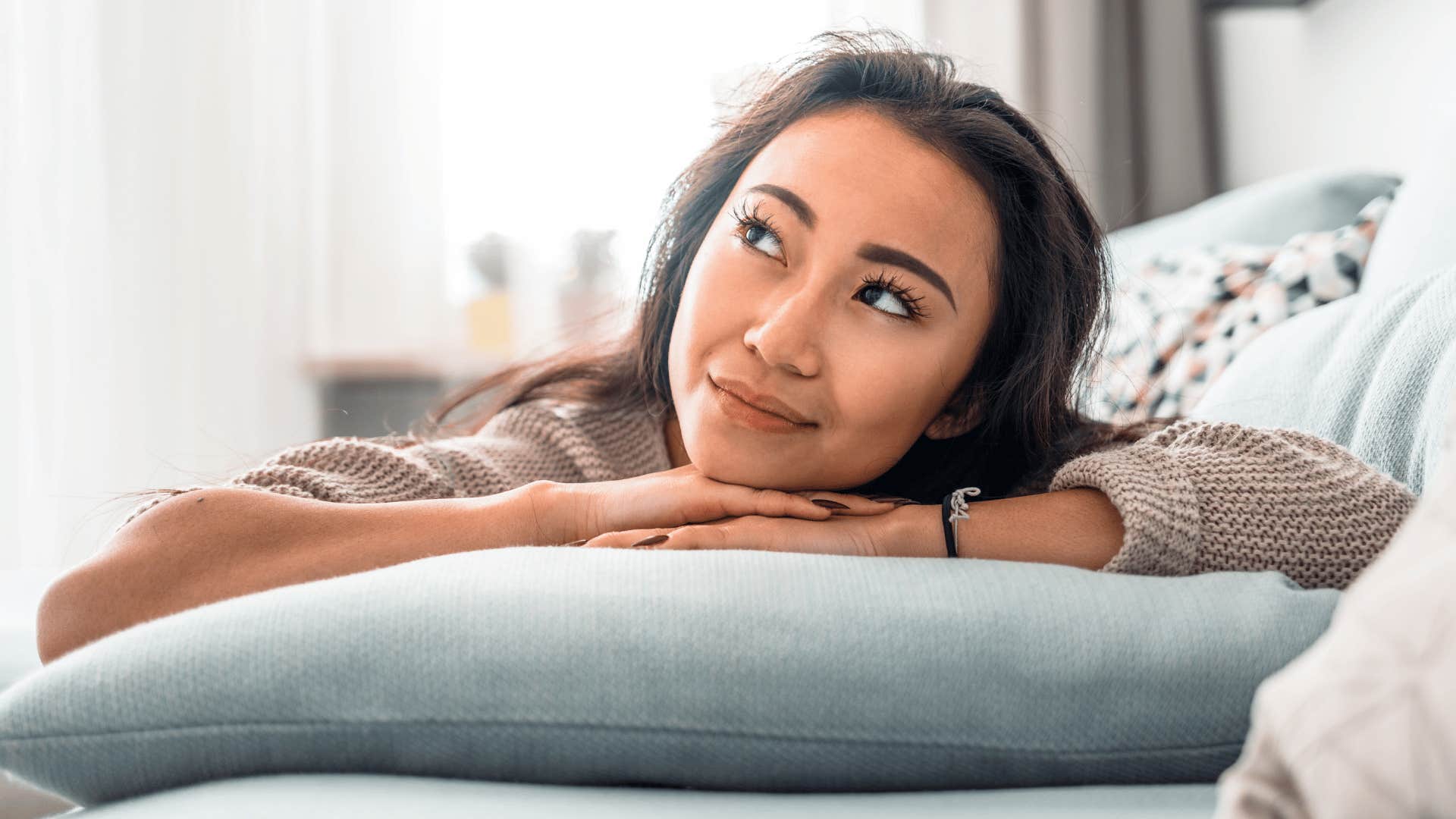 woman with a wild imagination daydreaming on her couch
