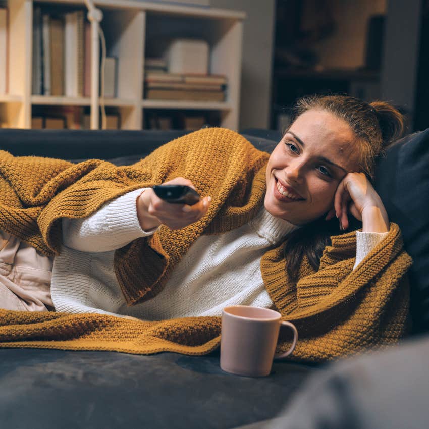 high iq woman who's nostalgic watching movies in a dark room at home.