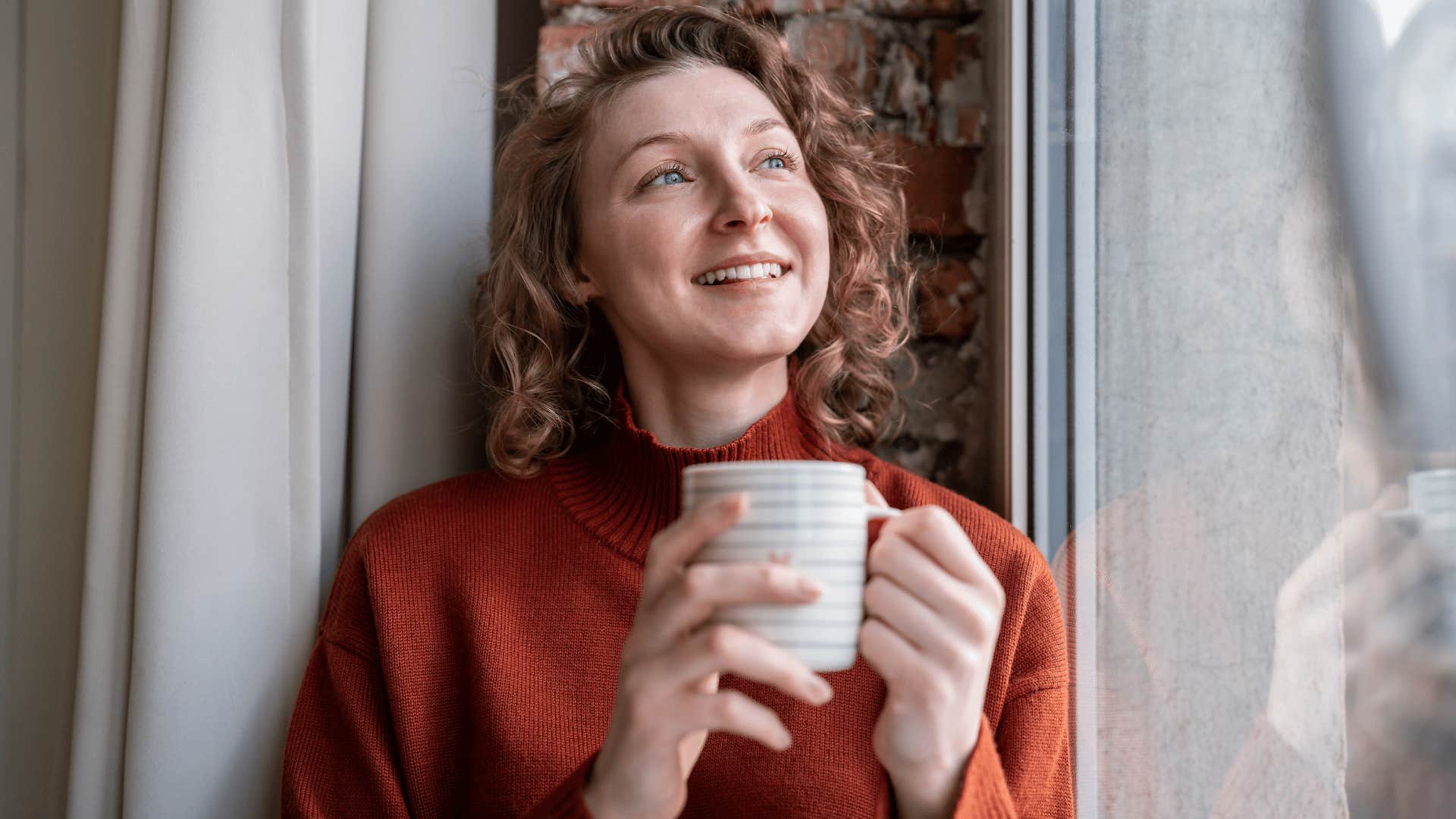woman in red shirt drinking coffee as she has better self care rituals 