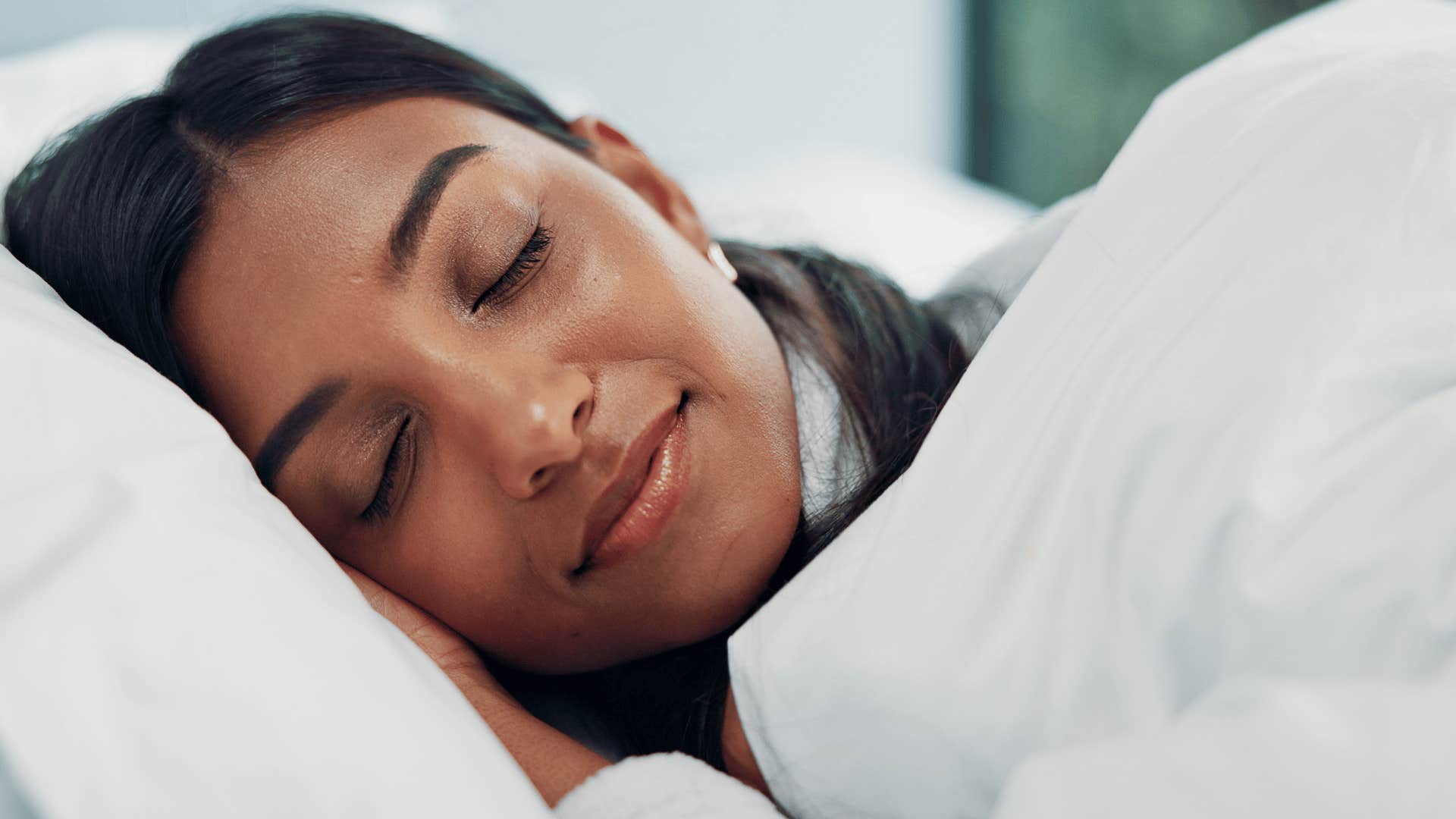 woman sleeping soundly in separate bedroom as she experiences better sleep quality