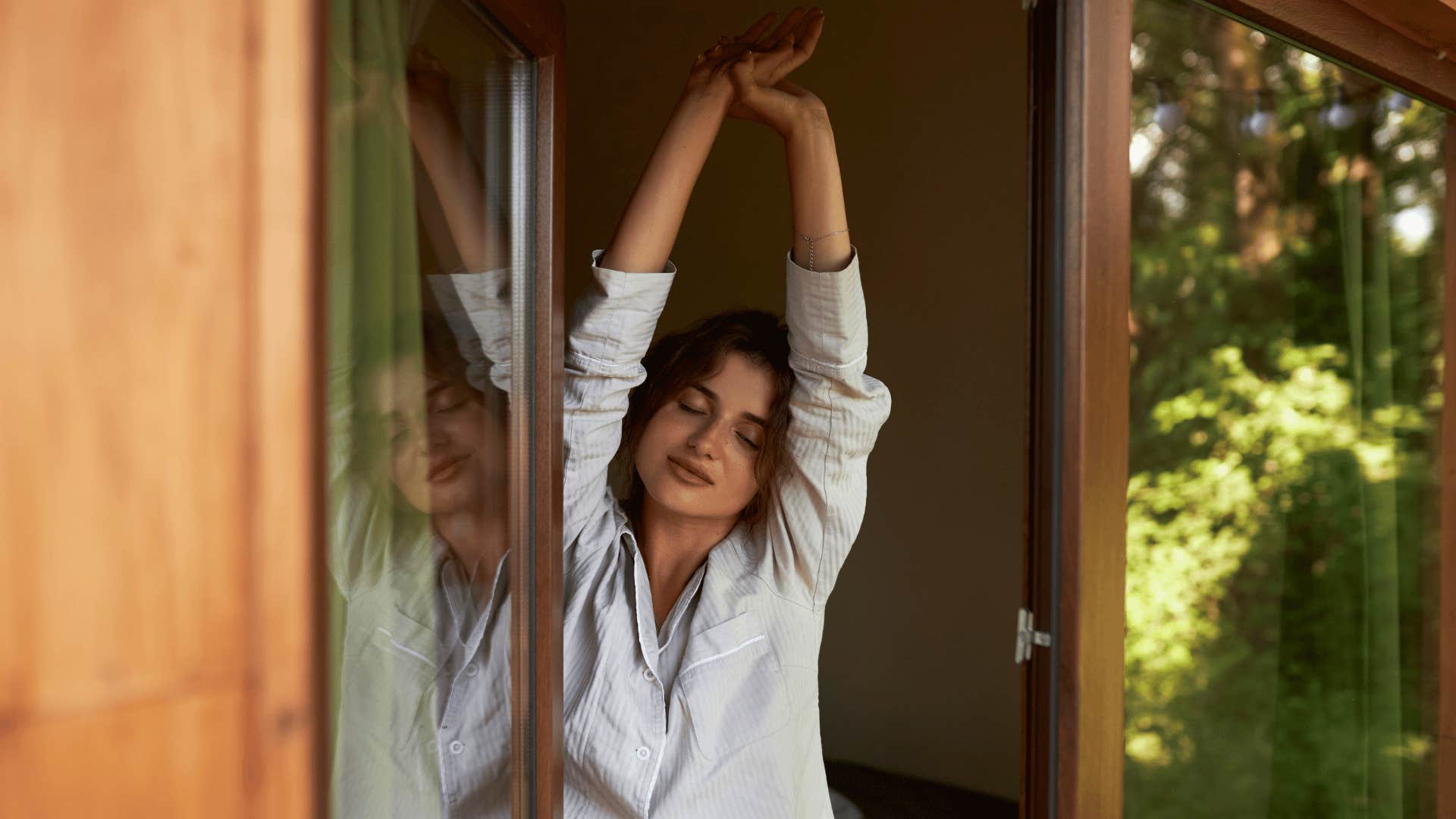 woman stretching in white shirt as she has higher energy during the day